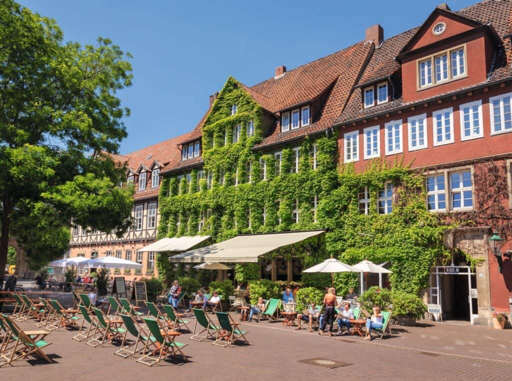 Altstadt Hannover mit Café, Bäumen und Sitzgelegenheiten.