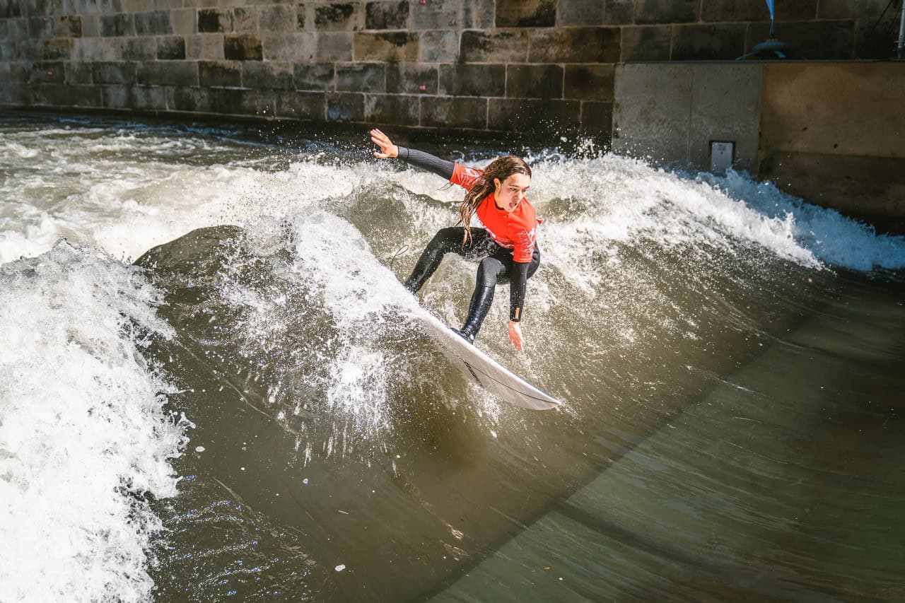 Jugendliche beim Surfen auf der Leinewelle in Hannover, Wassersport in der Stadt.