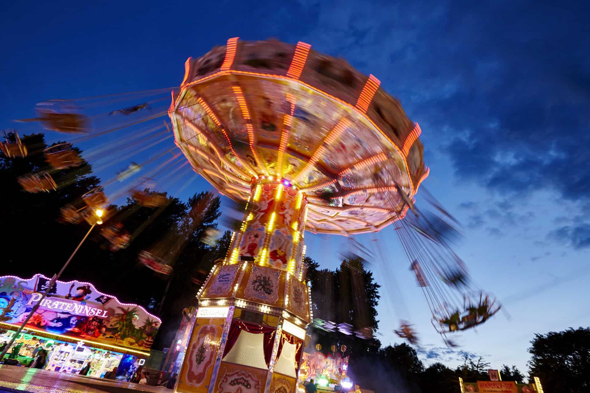 Hannover Schützenfest 2025 : carrousel multicolore avec des lumières au crépuscule.