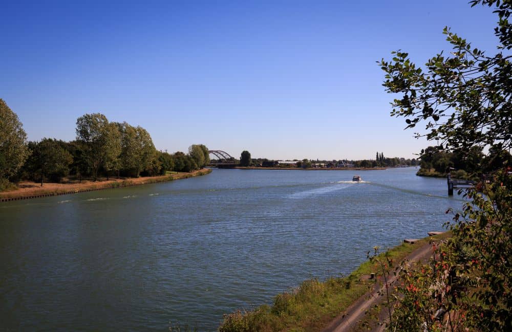 Blick auf den Kiessee Lohnde mit Wasser, Bäumen und Booten bei Hannover.