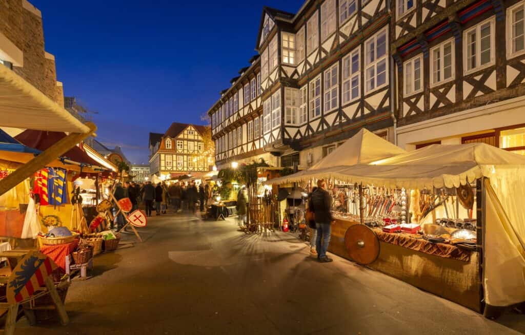 Belebter Nachtmarkt in der Altstadt von Hannover mit Ständen und Besuchern.