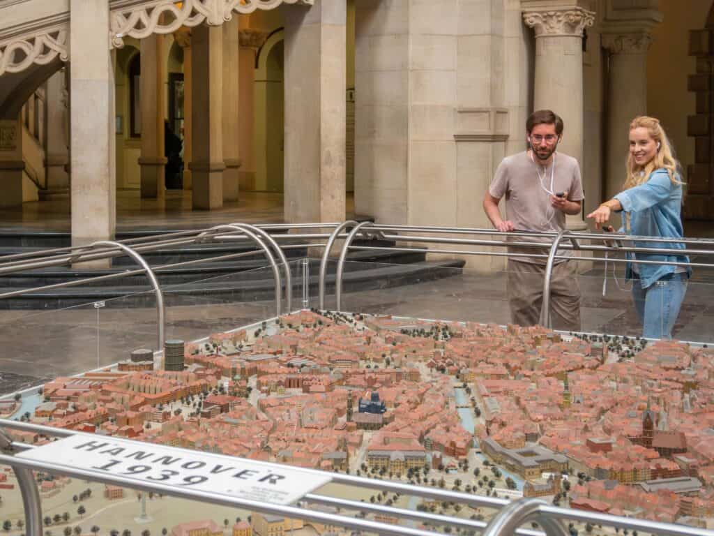 Besucher betrachten das detaillierte Stadtmodell von Hannover im Rathaus.