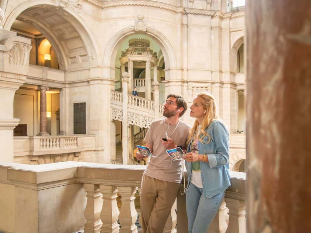 Besucher im Inneren des Neuen Rathauses Hannover, beeindruckende Architektur.