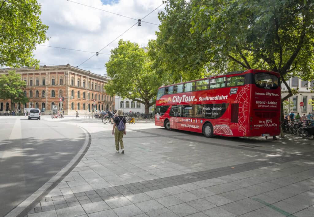 Doppeldecker-Bus für Stadtrundfahrt in Hannover, Touristen genießen die Stadtführung.