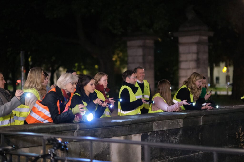 Gruppe bei der Taschenlampenführung in Hannover, nächtliche Stadtbesichtigung.
