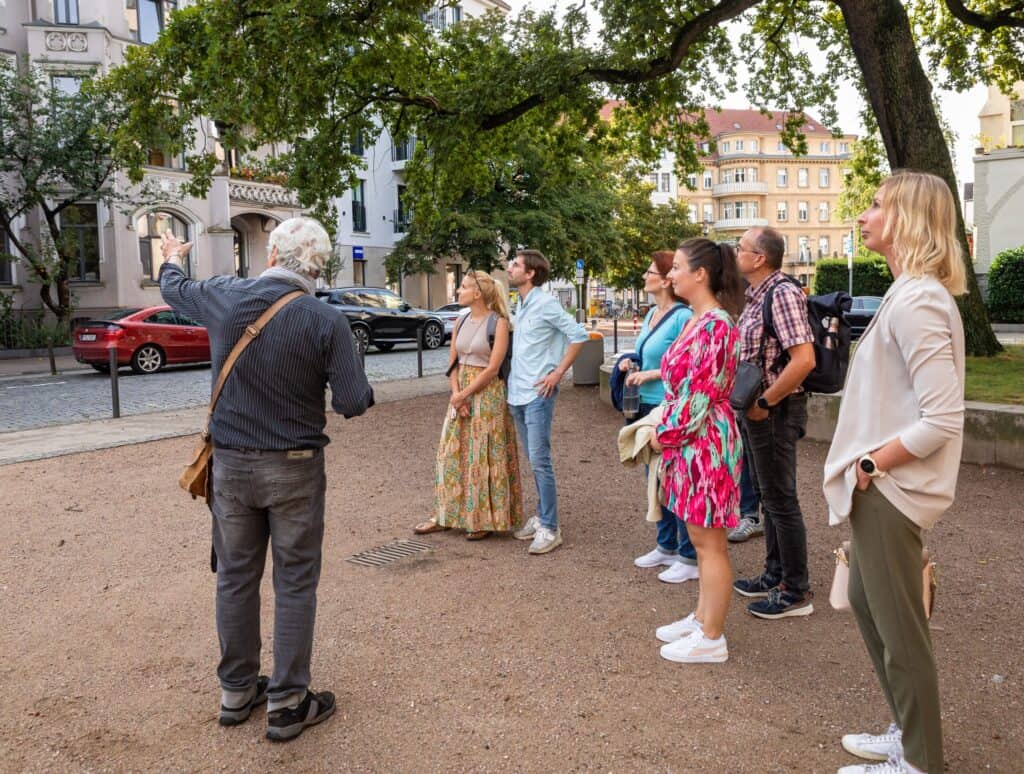 Stadtführer erklärt Tourgruppe Sehenswürdigkeiten in Hannover Oststadt.