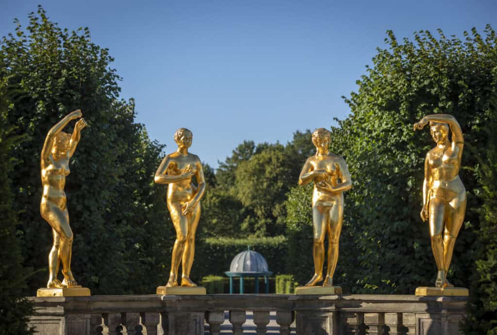 Vier goldene Skulpturen im Großen Garten Hannover bei schönem Wetter.