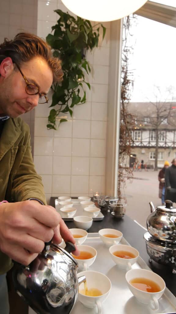 Mand serverer te på en britisk café i Hannover.