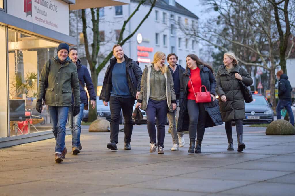 Fröhliche Menschen beim Spaziergang in der Südstadt von Hannover, genießen das urbane Flair und die.
