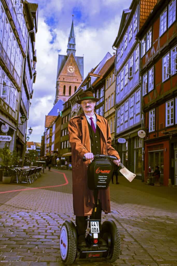 Mann auf Segway in Hannover Altstadt mit Kirche im Hintergrund.