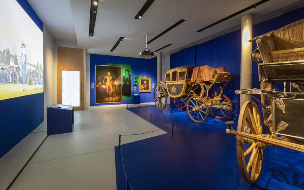 Museumsausstellung mit antiken Kutschen und Gemälden im Schloss Herrenhausen.