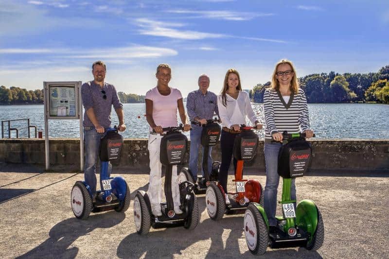 Gruppe von Menschen auf Segways bei einer Tour am Wasser in Hannover.