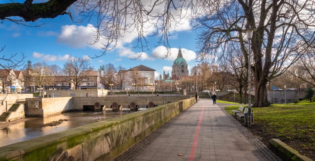 Spazierweg am Wasser in Hannover mit Blick auf die Stadt und den Dom.