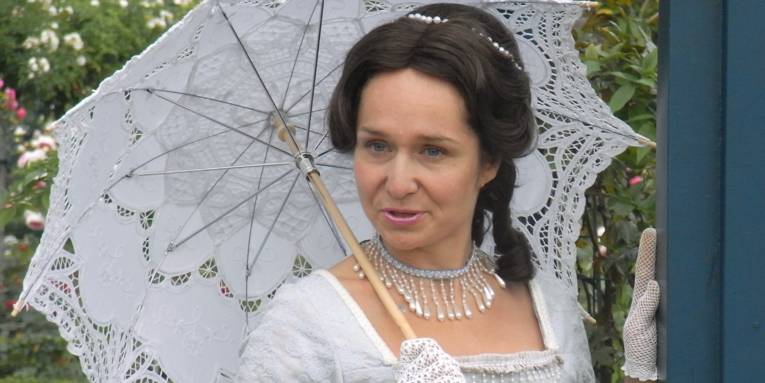 Frau in historische Kleidung mit Regenschirm im Großen Garten Hannover.