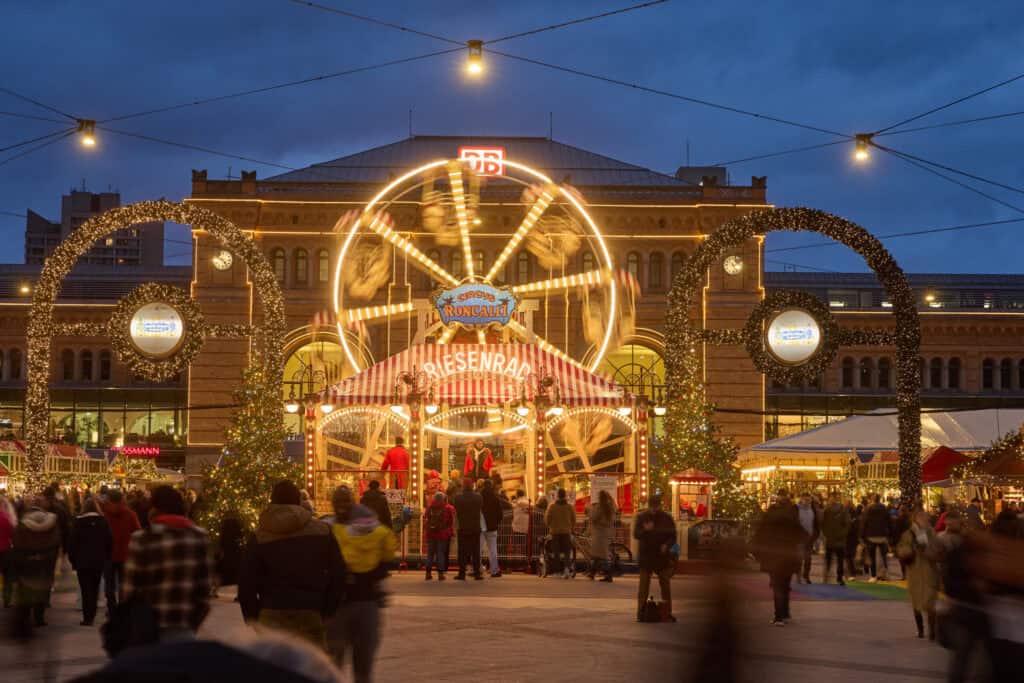 Leuchtender Weihnachtsmarkt in Hannover mit Karussell und festlicher Beleuchtung.