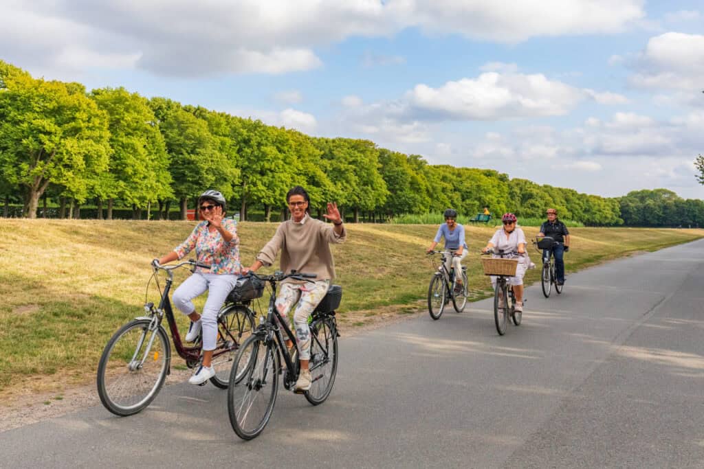 Gruppe von Radfahrern auf einer grünen Radroute in Hannover bei schönem Wetter.