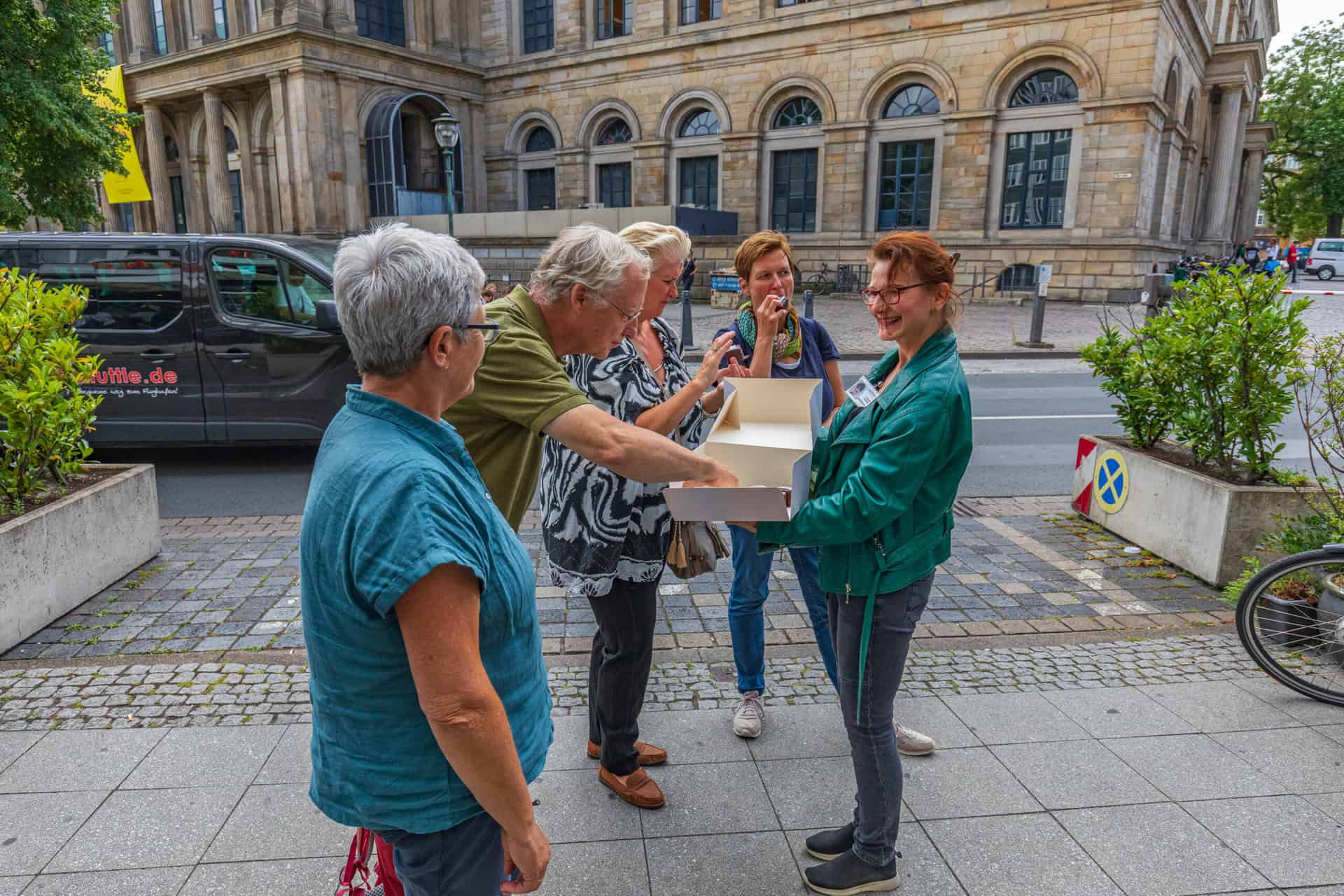 Frauen bei Stadtführung in Hannover, genießen lokale Spezialitäten im Freien.