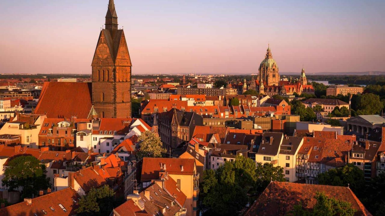 Altstadt Hannover mit historischen Gebäuden und Kirchtürmen bei Sonnenuntergang.