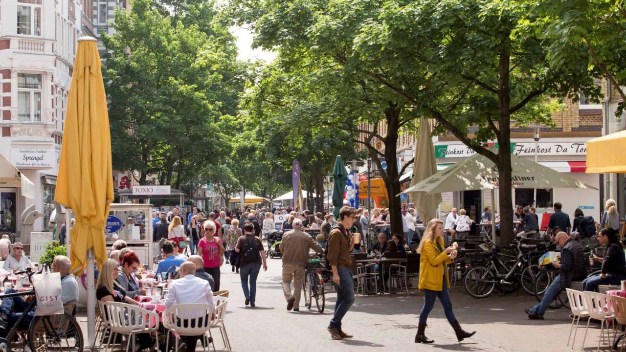 Lively street in Hanover with cafés and people outside.