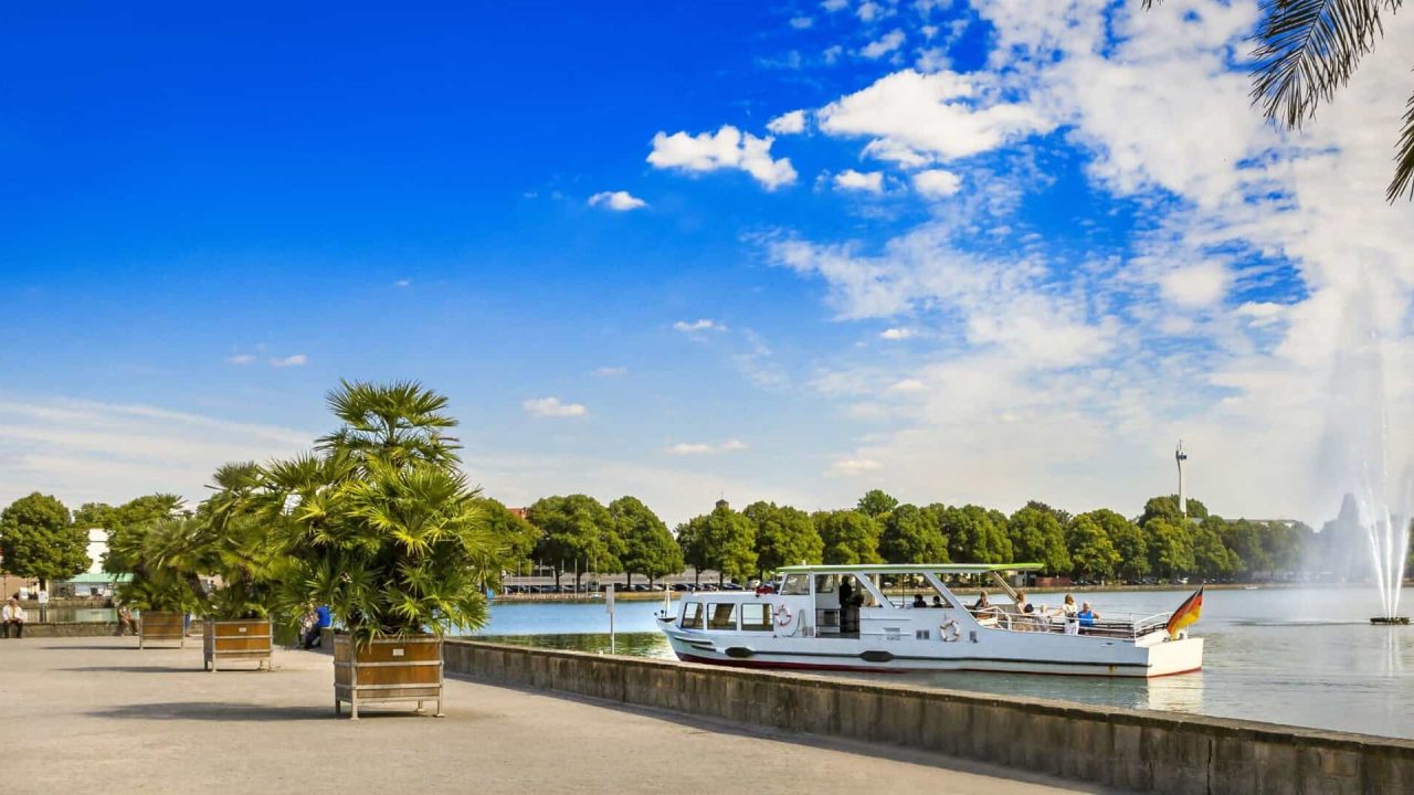 Vista del Maschsee di Hannover con barche e palme in estate.