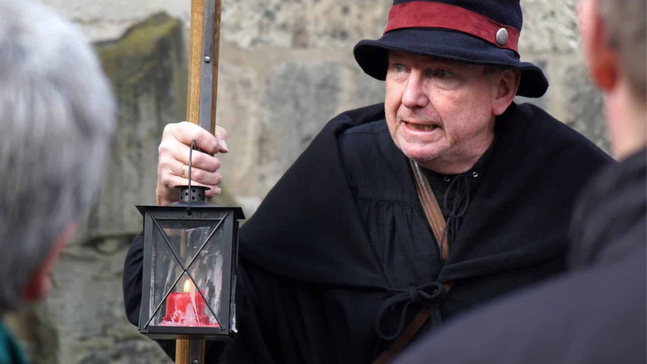 身着历史服饰的男子提着灯笼在汉诺威城市游览。.