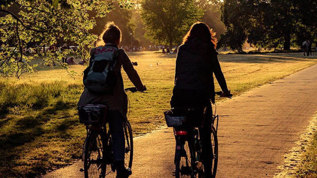 夕暮れのハノーバー・シティ・パークをサイクリングする2人の女性。.